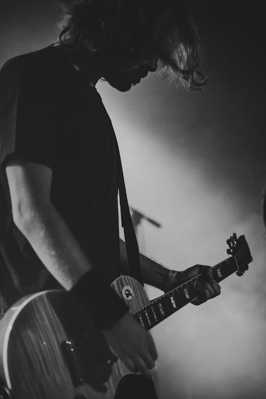 Guitarist bent over the fretboard in thick fog